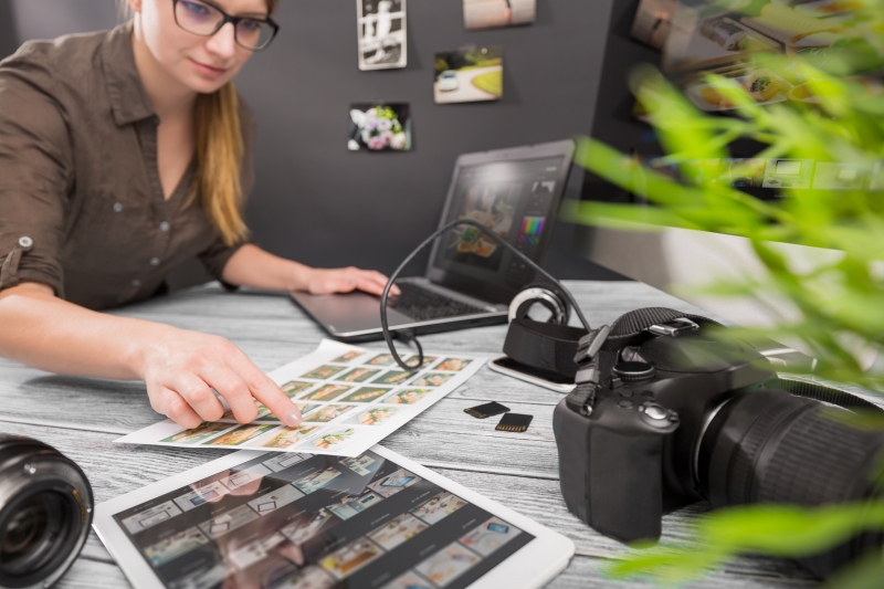 Photo of journalist looking at images, laptop and camera equipment